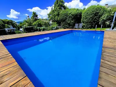 a large blue swimming pool on a wooden deck at Garni Tschutscherhof in Laion
