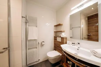 a white bathroom with a toilet and a sink at Garni Tschutscherhof in Laion