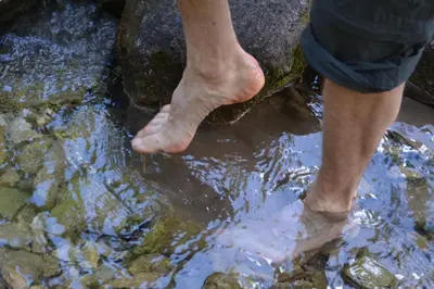 a person standing on a rock in the water at Schornhof in Aldino