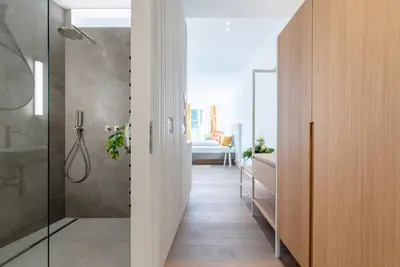 a bathroom with a walk in shower and a glass door at KERAMIK Suites in Merano