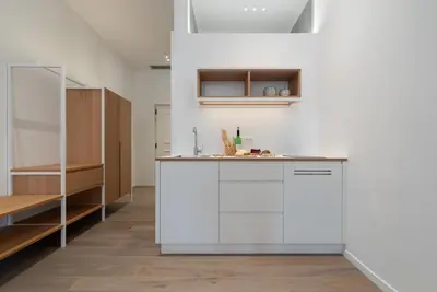 a kitchen with white cabinets and a counter at KERAMIK Suites in Merano