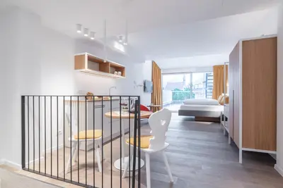 a room with two tables and two chairs and a bedroom at KERAMIK Suites in Merano