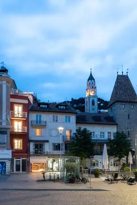 a city with a clock tower and a building at KERAMIK Suites in Merano