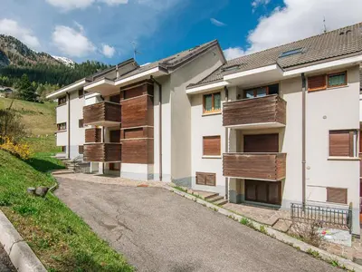 an apartment building with wooden balconies on a street at Apartment Enrosadira-9 by Interhome in Alba di Canazei