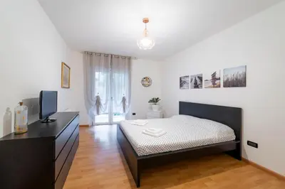 a bedroom with a bed and a dresser with a television at Terrace 27 in Bolzano