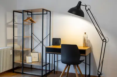 a desk with a black lamp and a chair at Terrace 27 in Bolzano