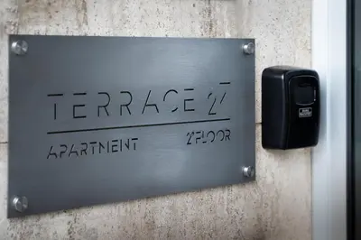 a metal sign on a wall with writing on it at Terrace 27 in Bolzano