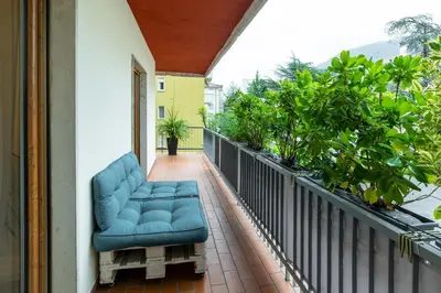 a porch with a blue chair on a balcony at Terrace 27 in Bolzano
