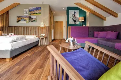 a living room with a bed and a couch at Seehotel Sparer in Appiano sulla Strada del Vino