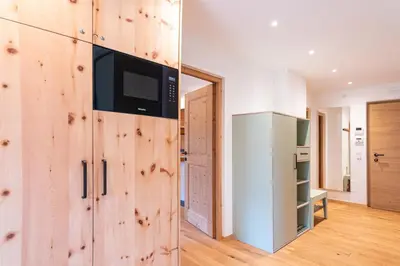 a kitchen with wooden walls and a refrigerator at Apartments Vedl Luech da Plajes in Ortisei