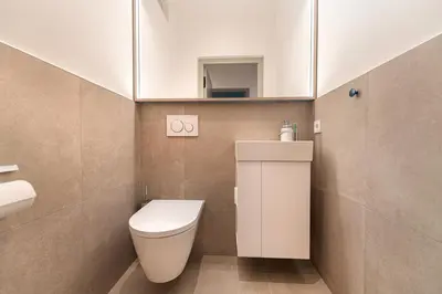 a small bathroom with a toilet and a mirror at Apartments Vedl Luech da Plajes in Ortisei