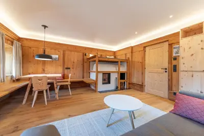 a living room with wooden walls and a table and chairs at Apartments Vedl Luech da Plajes in Ortisei