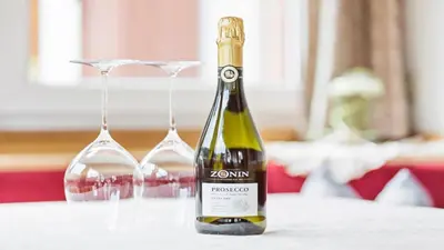 a bottle of wine and two glasses on a table at Apartments Villa Alpina in Santa Cristina in Val Gardena