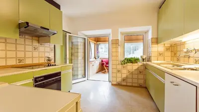 a kitchen with green and yellow walls and a sink at Apartments Villa Alpina in Santa Cristina in Val Gardena