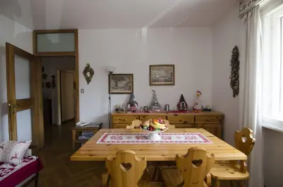 a dining room with a wooden table and a table and chairs at Accogliente appartamento in Corso Italia in Cortina dʼAmpezzo
