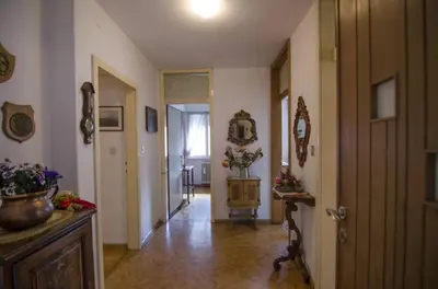 a hallway of a home with a door and a table with flowers at Accogliente appartamento in Corso Italia in Cortina dʼAmpezzo
