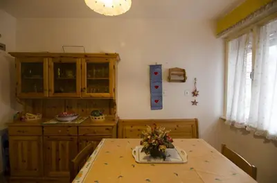 a kitchen with a wooden table and a dining room at Accogliente appartamento in Corso Italia in Cortina dʼAmpezzo
