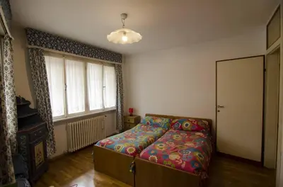 a bedroom with a bed and a large window at Accogliente appartamento in Corso Italia in Cortina dʼAmpezzo