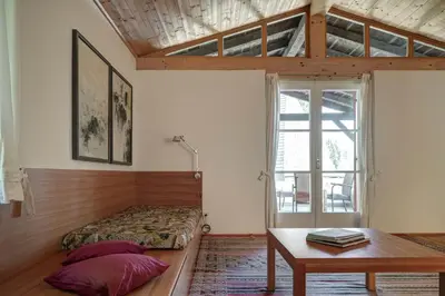a bedroom with a bed and a table and a window at Landhaus Leonhard in Egna
