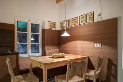 a dining room with a wooden table and chairs at Landhaus Leonhard in Egna