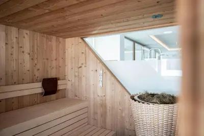 a sauna with a staircase in a wooden house at Passo Sella Dolomiti Mountain Resort in Selva di Val Gardena