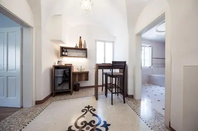 a living room with a table and a bathroom at Romantik Hotel Jagdhof in Caldaro
