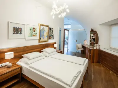 a bedroom with a large bed and a desk at Romantik Hotel Jagdhof in Caldaro