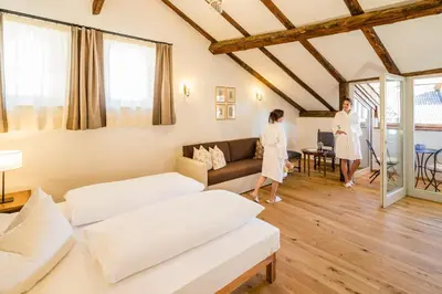 two women are standing in a living room at Romantik Hotel Jagdhof in Caldaro