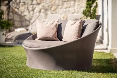 a couch sitting on the grass in a yard at Romantik Hotel Jagdhof in Caldaro