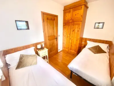 two beds in a room with a door at FALORIA APARTMENT-splendid view in Cortina dʼAmpezzo