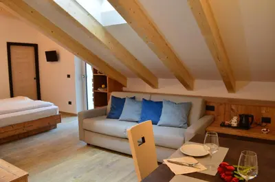 a living room with a couch and a table at Aria Alpina Guest House Affittacamere in Predazzo