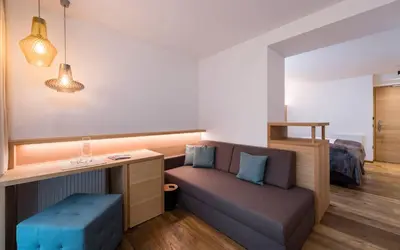 a bedroom with two beds and two windows at Villa Tony - Small Romantic Hotel in Corvara in Badia