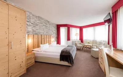 a living room with a red couch and a window at Villa Tony - Small Romantic Hotel in Corvara in Badia