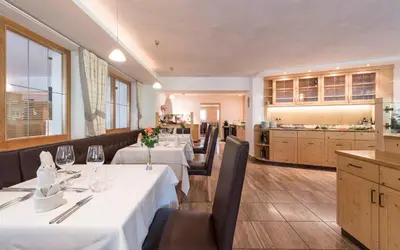 a person pouring a glass of wine on a table at Villa Tony - Small Romantic Hotel in Corvara in Badia