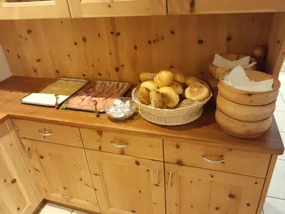 a wooden cabinet with baskets of bread and other items on it at Landgasthof Sonnegghof in Castelvecchio