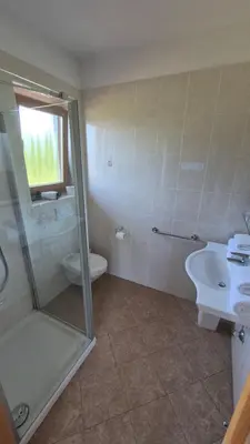 a bathroom with a shower and a sink and a toilet at Landgasthof Sonnegghof in Castelvecchio