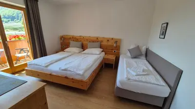 a bedroom with two beds and a balcony at Landgasthof Sonnegghof in Castelvecchio