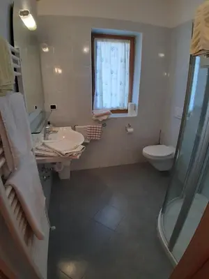 a bathroom with a sink and a toilet and a window at Landgasthof Sonnegghof in Castelvecchio
