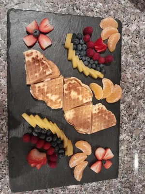 a cutting board with different types of cheese and fruit at Landgasthof Sonnegghof in Castelvecchio