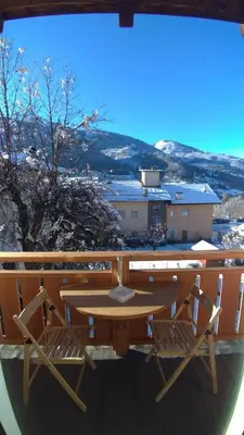 a table and chairs on a balcony with a view of a mountain at Casa Micéi in Tesero