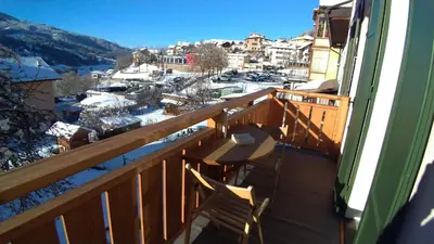 a balcony with a bench and a view of a town at Casa Micéi in Tesero