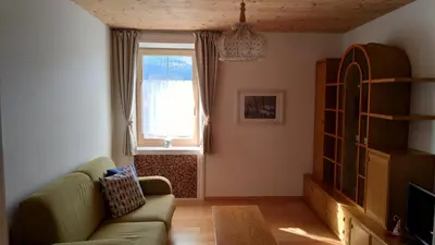 a living room with a couch and a window at Casa Micéi in Tesero
