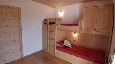 a room with two bunk beds and a closet at Casa Micéi in Tesero