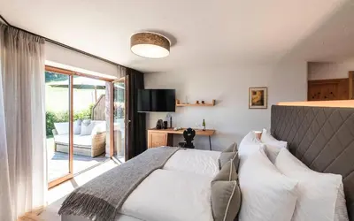 a bedroom with a bed and a sliding glass door at Exclusive Chalet Grumer 700 sqm in Soprabolzano