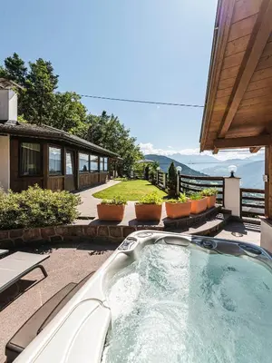 a hot tub on the patio of a house at Exclusive Chalet Grumer 700 sqm in Soprabolzano