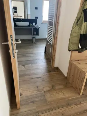a hallway with a wooden floor and a bathroom at Appart-Chalet Litegosa in Panchia