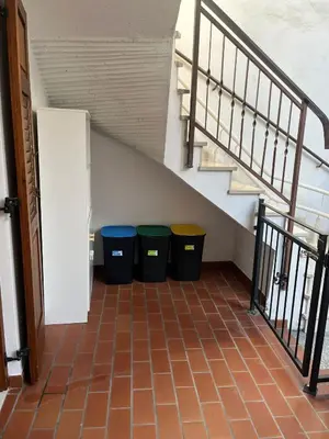 three trash cans sitting under a stair case at Casa Romy in Rovere della Luna
