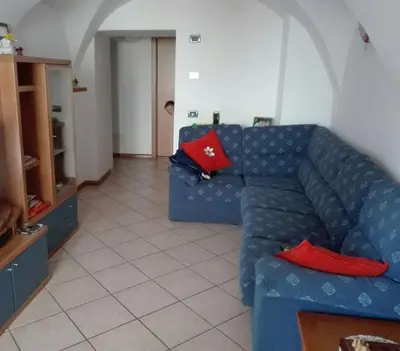 a living room with a blue couch and red pillows at Casa Romy in Rovere della Luna