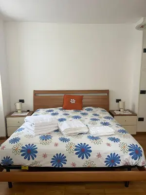 a bedroom with a bed with a white and blue blanket at Casa Romy in Rovere della Luna