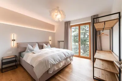 a bedroom with a bed and a large window at Promenaden Lounge in Merano